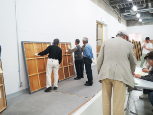 展覧会業務はここから始まります。作品の搬入(左)とずらりと並んだ応募書類の受付(右)